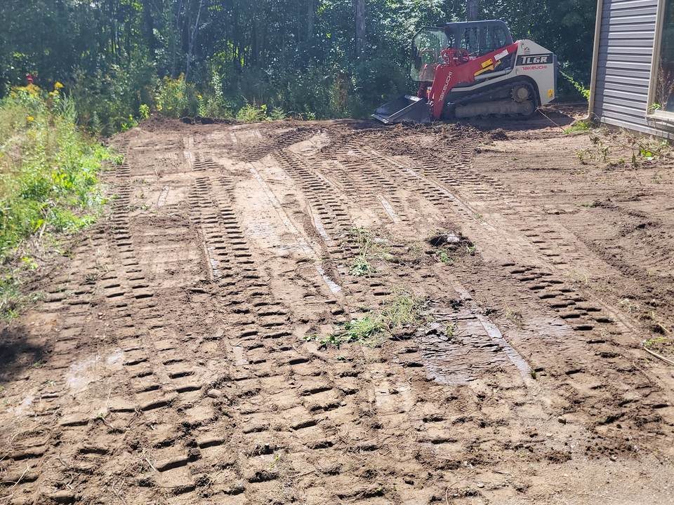 Backyard after grading: bare soil with machine tracks, before sod