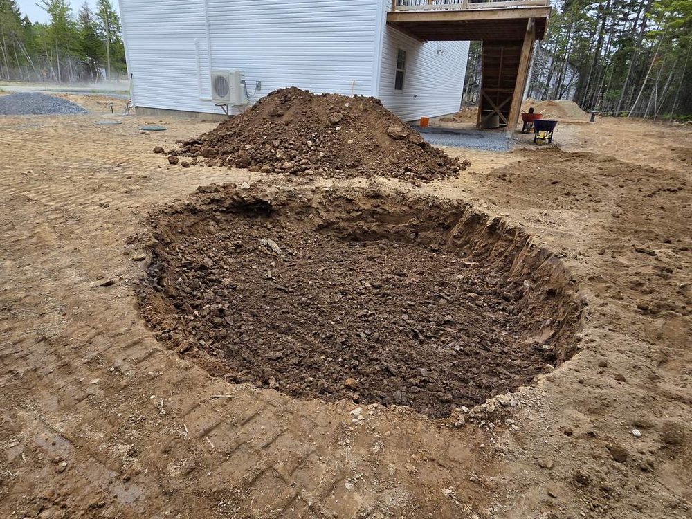 Topsoil spread on a graded yard beside a new house